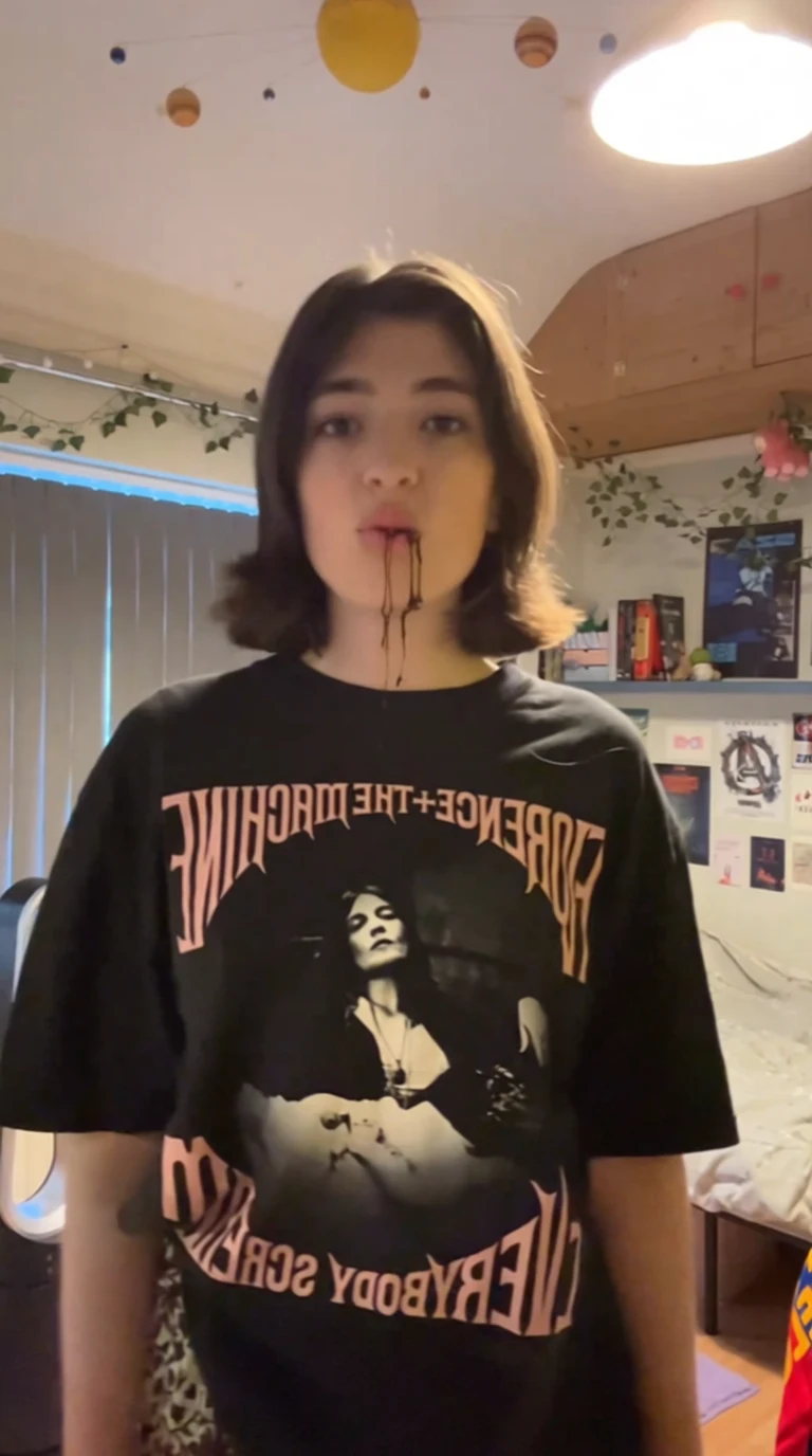 Person wearing black Florence + The Machine t-shirt with chocolate