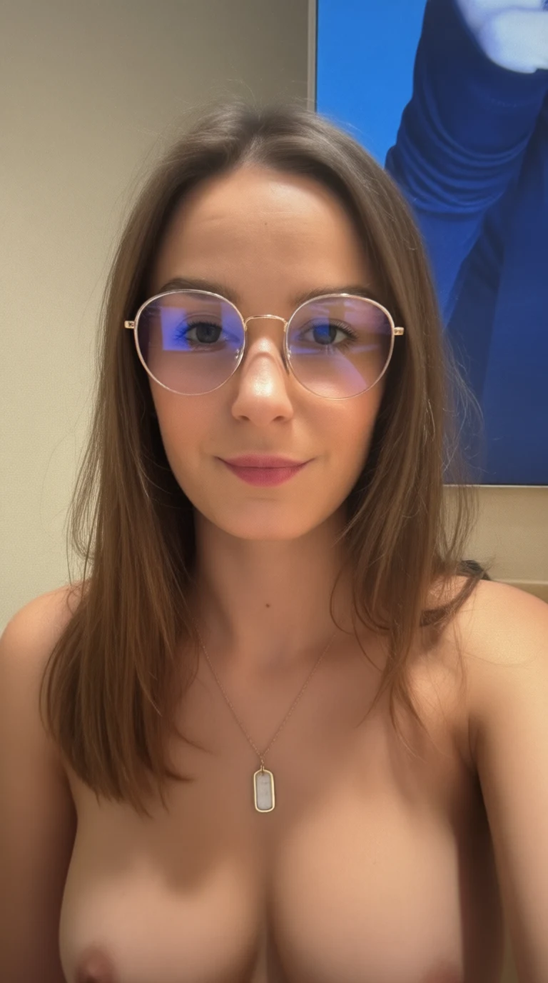 A woman with brown hair and round glasses smiles while wearing a gold